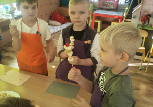 Dzieci nadziewaja owoce na patyki szaszłykowe