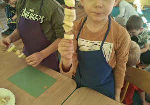 Dzieci nadziewaja owoce na patyki szaszłykowe