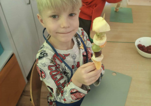 Dzieci nadziewaja owoce na patyki szaszłykowe