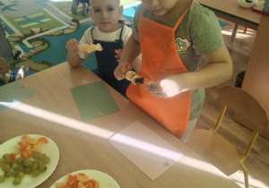 Dzieci nadziewaja owoce na patyki szaszłykowe