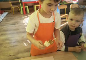 Dzieci nadziewaja owoce na patyki szaszłykowe