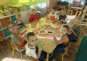 Dzieci nadziewaja owoce na patyki szaszłykowe