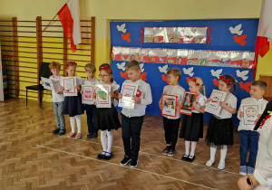 Dzieci z gr 4 recytują wiersz i pokazują obrazki