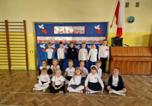 Dzieci z gr 4 w strojach galowych pozują na tle dkoracji