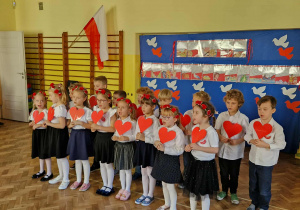 Dzieci z gr 4 trzymają w ręku czerwone serduszka