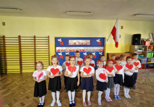 Dzieci z gr 4 trzymają w ręku czerwone serduszka