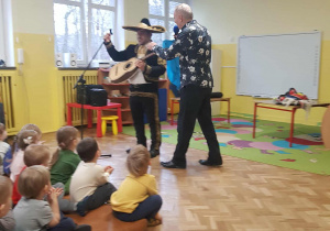 Dzieci oglądają pana który gra na gitarze