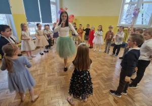 Dzieci ustawione w kole w środku stoi pani wróżka