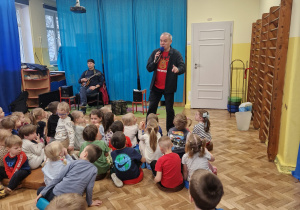 Pan z mikrofonem śpiewa z dziećmi piosenkę