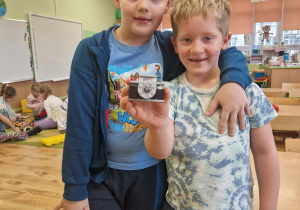 Chłopcy prezentują aparat fotograficzny zbudowany z klocków