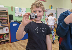 Chłopiec prezentuje aparat fotograficzny zbudowany z klocków