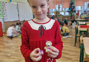 Dziewczynka prezentuje swoją budowle z klocków lego
