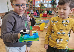 Chłopcy prezentują budowlę z klocków lego