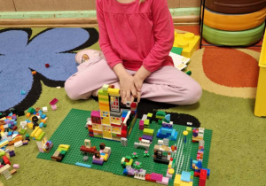 Dziewczynka prezentuje swoją budowlę z klocków lego