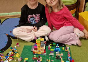 Dziewczynki prezentują swoją budowlę z klocków lego