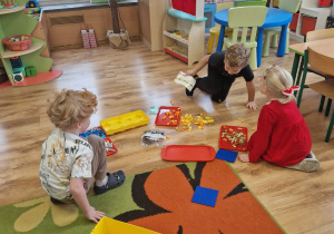 Dzieci czytają instrukcję przed budowaniem z klocków