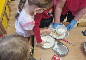 Dzieci przesypują mąkę przez sitko