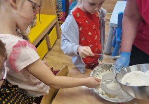 Dzieci przesypują mąkę przez sitko