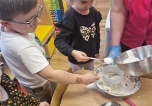 Dzieci przesypują mąkę przez sitko