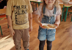 Dzieci idą do innej grupy z życzeniami i słodkim poczestunkiem