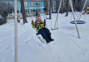 Chłopiec huśta się na huśtawce