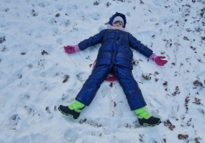 Dziewczynka robi na śniegu aniołka