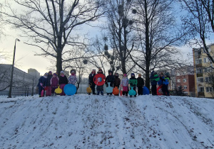 Dzieci przygotowują się do zjeżdżania z górki na plastikowych jabłkach