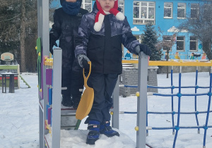 Dzieci bawią się na urządzeniach terenowych