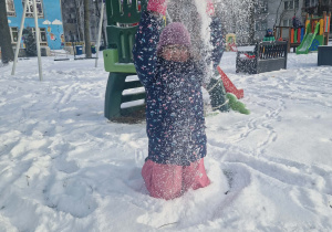 Dziewczynka sypie śniegiem