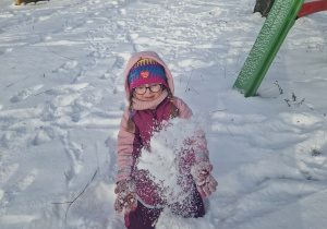 Dziewczynka sypie śniegiem