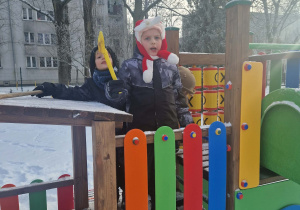 Dzieci odśnieżają urządzenia w ogrodzie