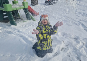 Chłopiec sypie śniegiem