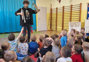 Pan pokazuje dzieciom dwa instrumenty