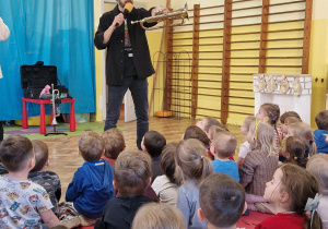 Pan prezentuje dzieciom trąbkę