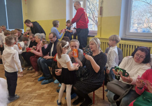 Dzieci wręczają prezenty dla babć i dziadków