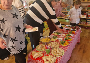 Dziadkowie uczestniczą w warsztatach kulinarnych z wnukami