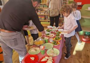Dziadkowie uczestniczą w warsztatach kulinarnych z wnukami
