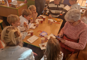 Dziadkowie uczestniczą w warsztatach kulinarnych z wnukami