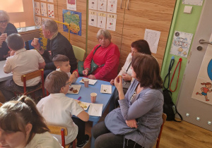 Dziadkowie uczestniczą w warsztatach kulinarnych z wnukami