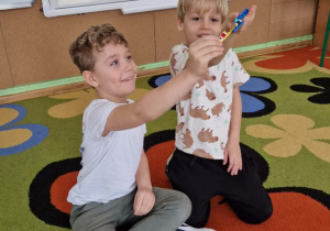 Dwóch chłopców prezentuje swoje budowle z klocków lego