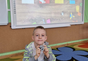 Chłopiec prezentuje swoją budowlę z klocków lego