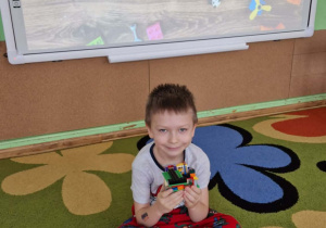 Chłopiec prezentuje swoją budowlę z klocków lego