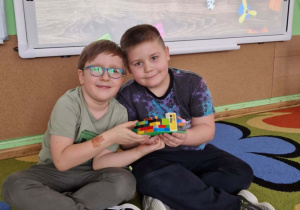 Dwóch chłopców prezentuje swoje budowle z klocków lego