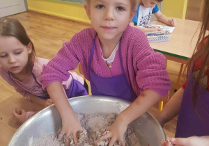 Dziewczynka zagniata piernikowe ciasto