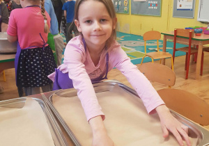 Dziewczynka rozkłada papier do pieczenia.