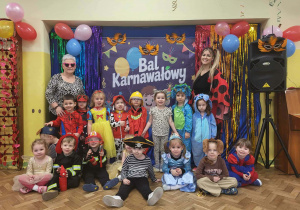 Dzieci z paniami pozują na tle dekoracji karnawałowej