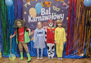 Dzieci w przebraniach pozują na tle dekoracji
