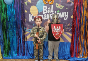 Dzieci w przebraniach pozują na tle dekoracji