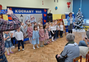 Dzieci stoją przed dziadkami