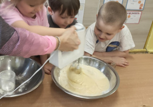 Dziewczynka miksuje składniki na babeczki